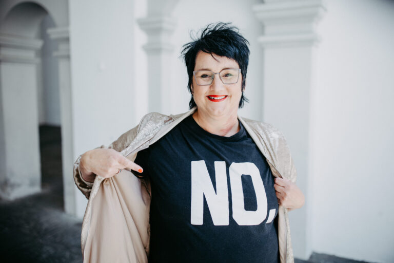 Sabine, Coach für Führungsfrauen steht mit einem schwarzen Tshirt auf dem NO steht in Ravensburg.