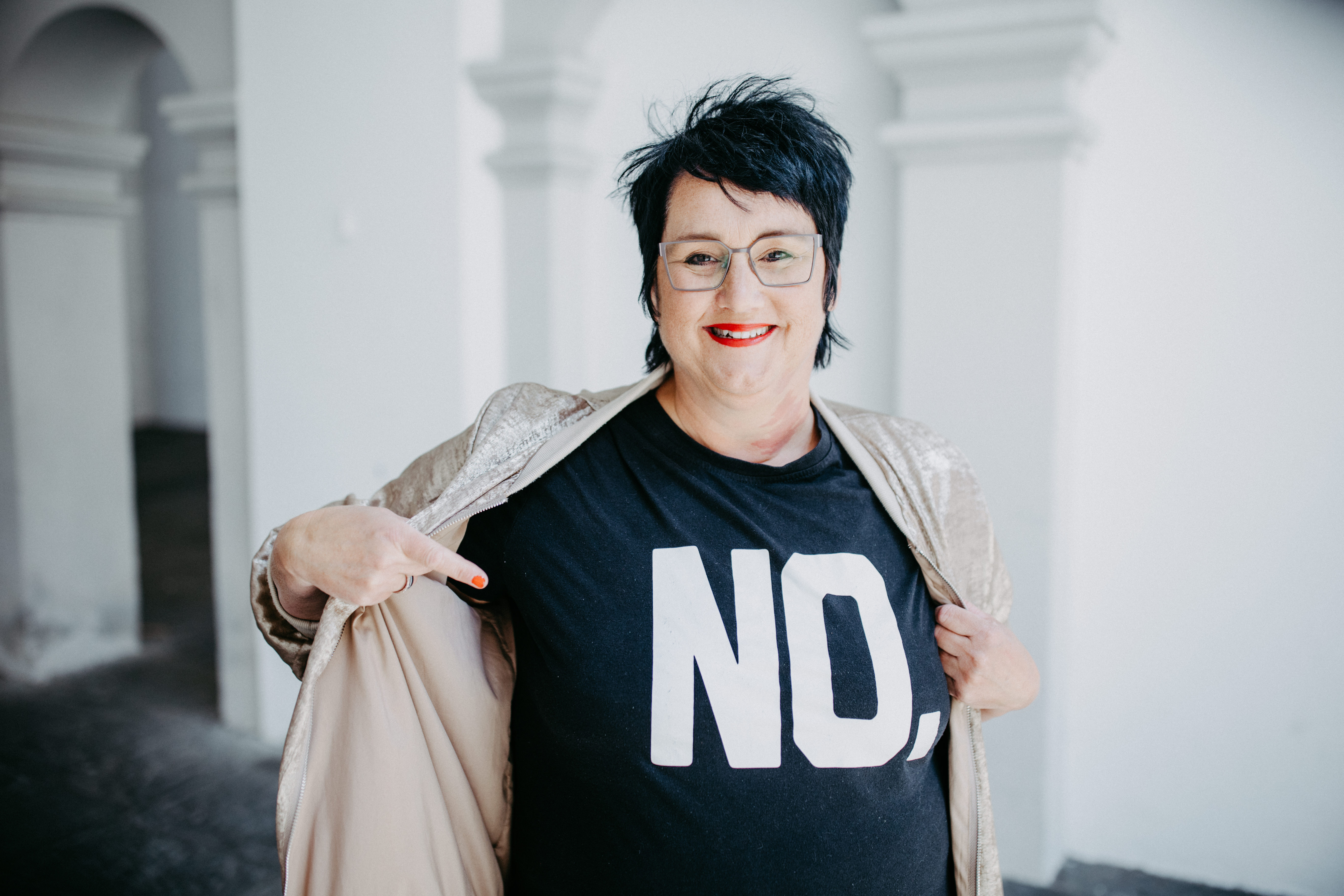 Sabine, Coach für Führungsfrauen steht mit einem schwarzen Tshirt auf dem NO steht in Ravensburg.