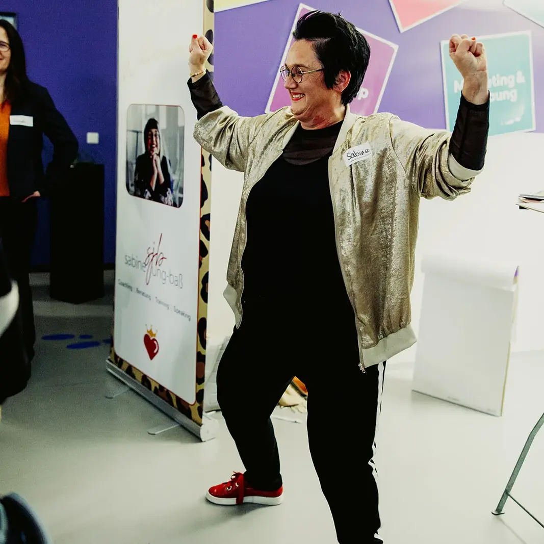 Sabine, die Führungskräfte coacht und Seminare zu Schlagfertigkeit gibt, macht eine Powerpose.