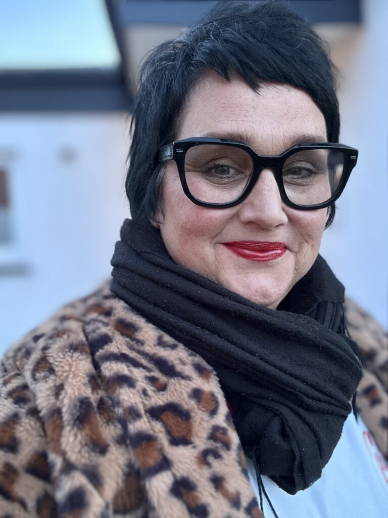 Sabine, Coach für Führungfrauen und Speakerin, lächelt in die Kamera.