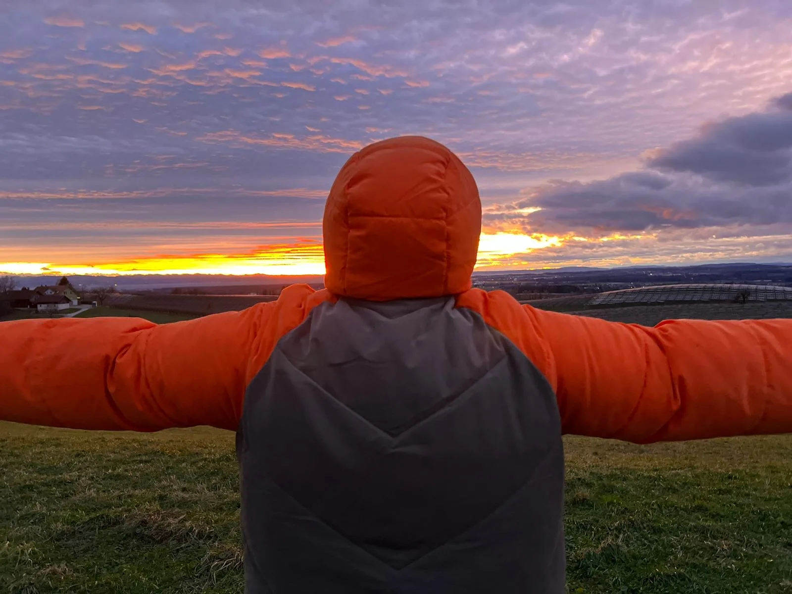 Sabine, Coach für female leadership, Speakerin und Trainerin steht vor einem Sonnenuntergang und breitet die Arme aus. 